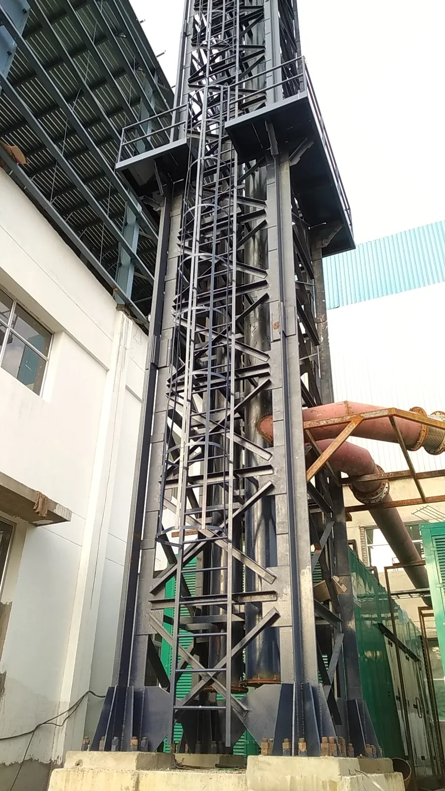 Tall heavy steel support tower with bracing and maintenance platforms