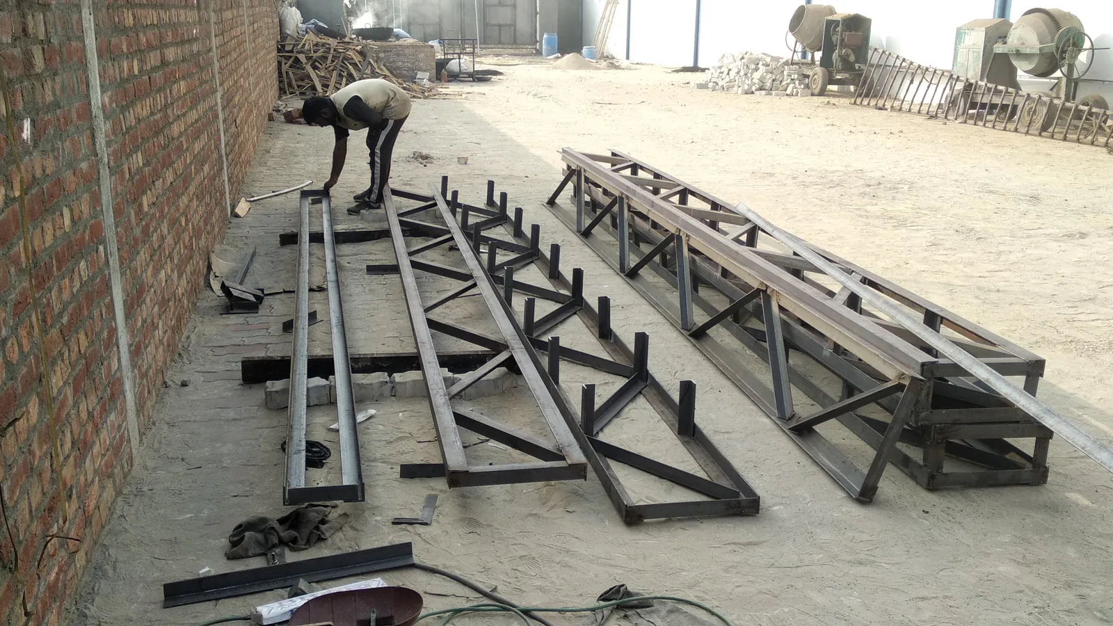 Structural steel truss members arranged for workshop fabrication