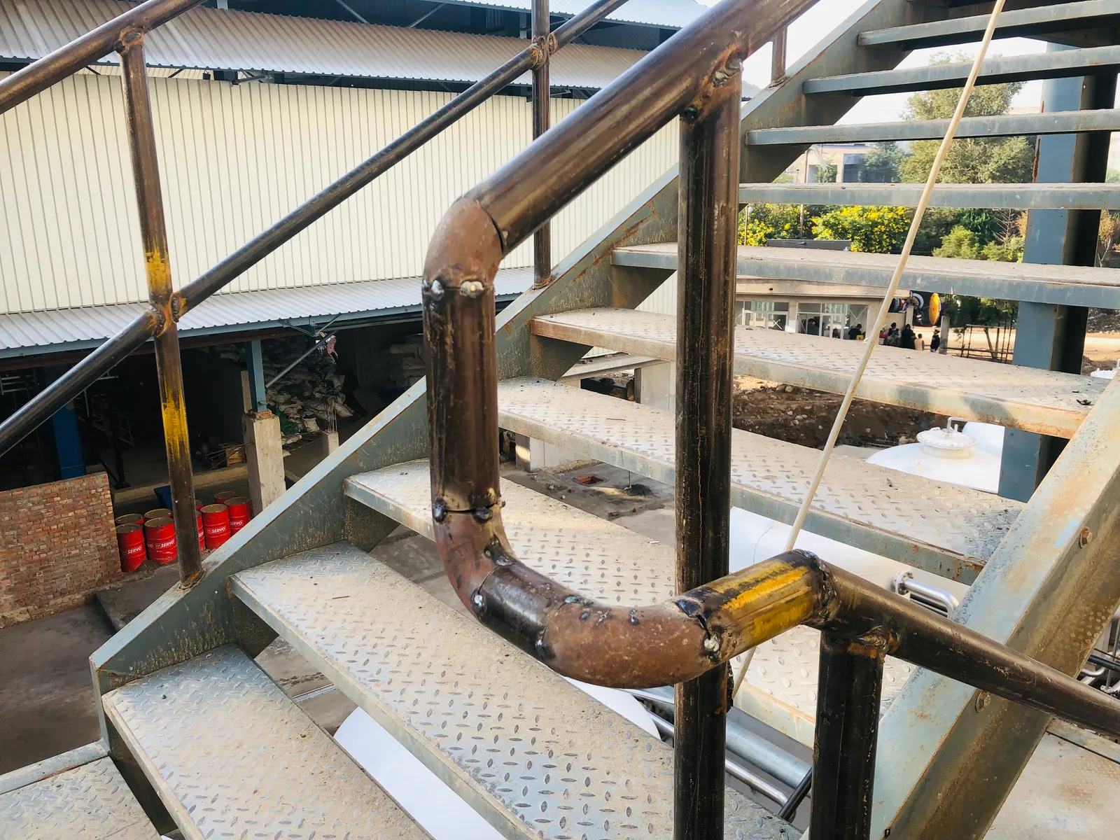 Steel handrail being fitted to an industrial stair structure
